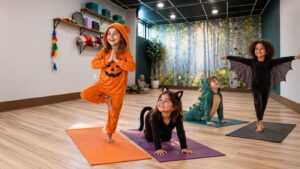 Children in Halloween costumes practicing kids yoga in a warm, sunlit studio in Bethlehem, PA
